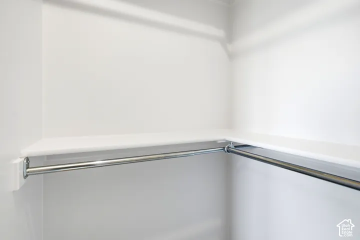 Corner closet with integrated shelving and chrome hanging rods