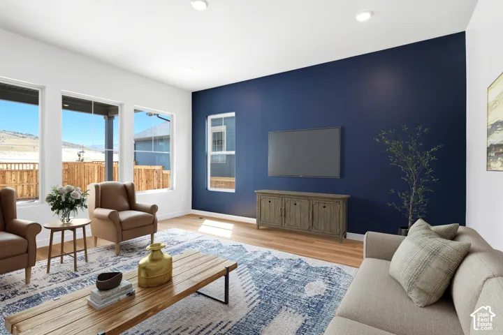 Open living space featuring wood-finish flooring and a distinctive accent wall