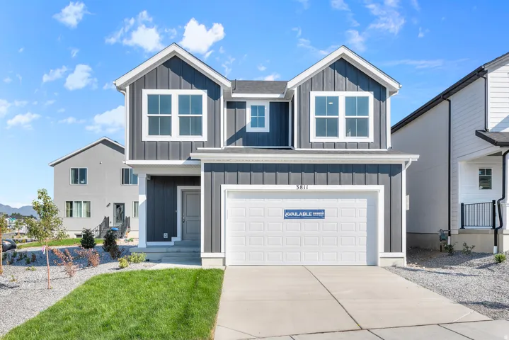 Modern two-story residence featuring dark vertical siding and white trim
