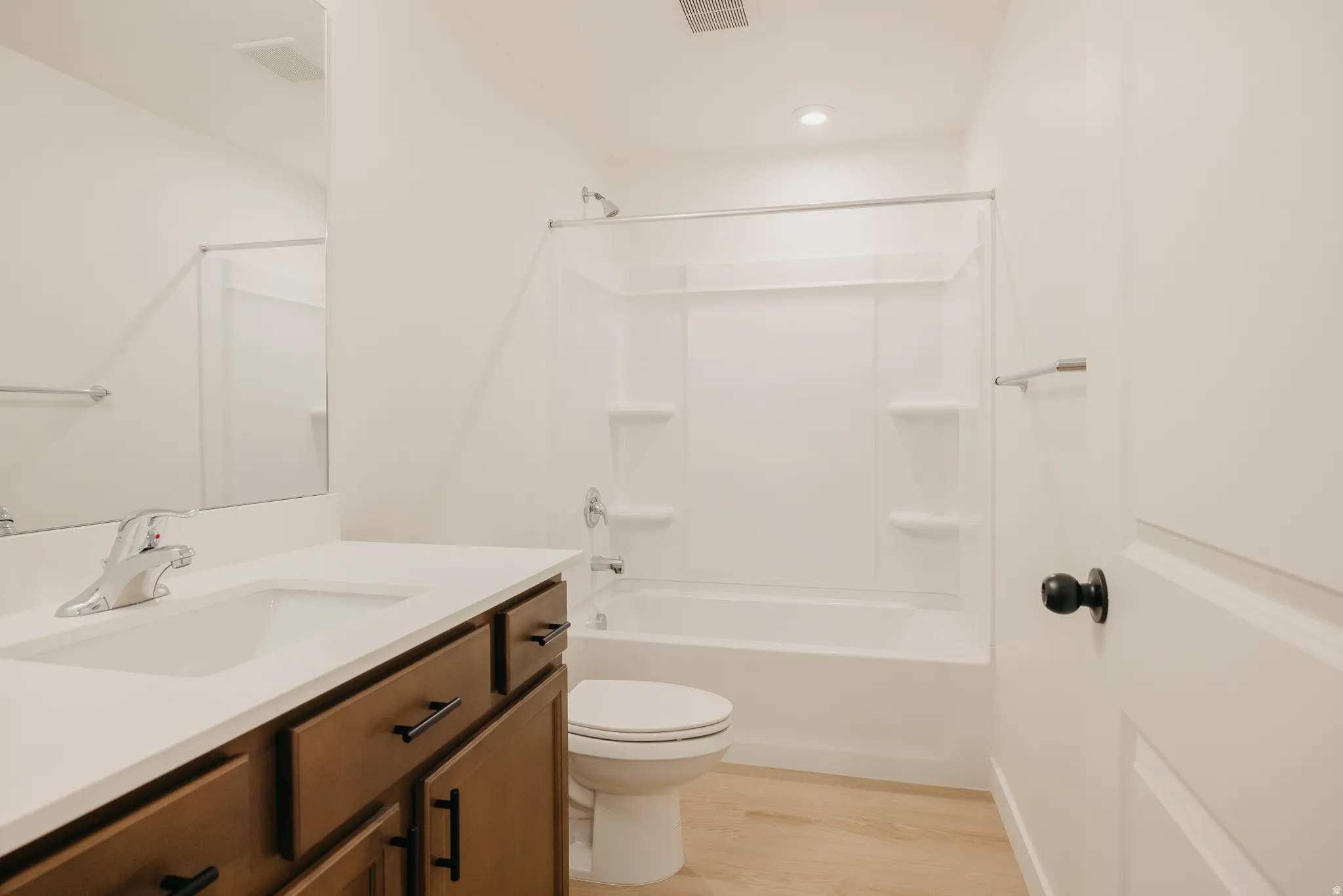 Bathroom featuring a single vanity with wood-finish cabinetry, a white countertop, and an integrated sink