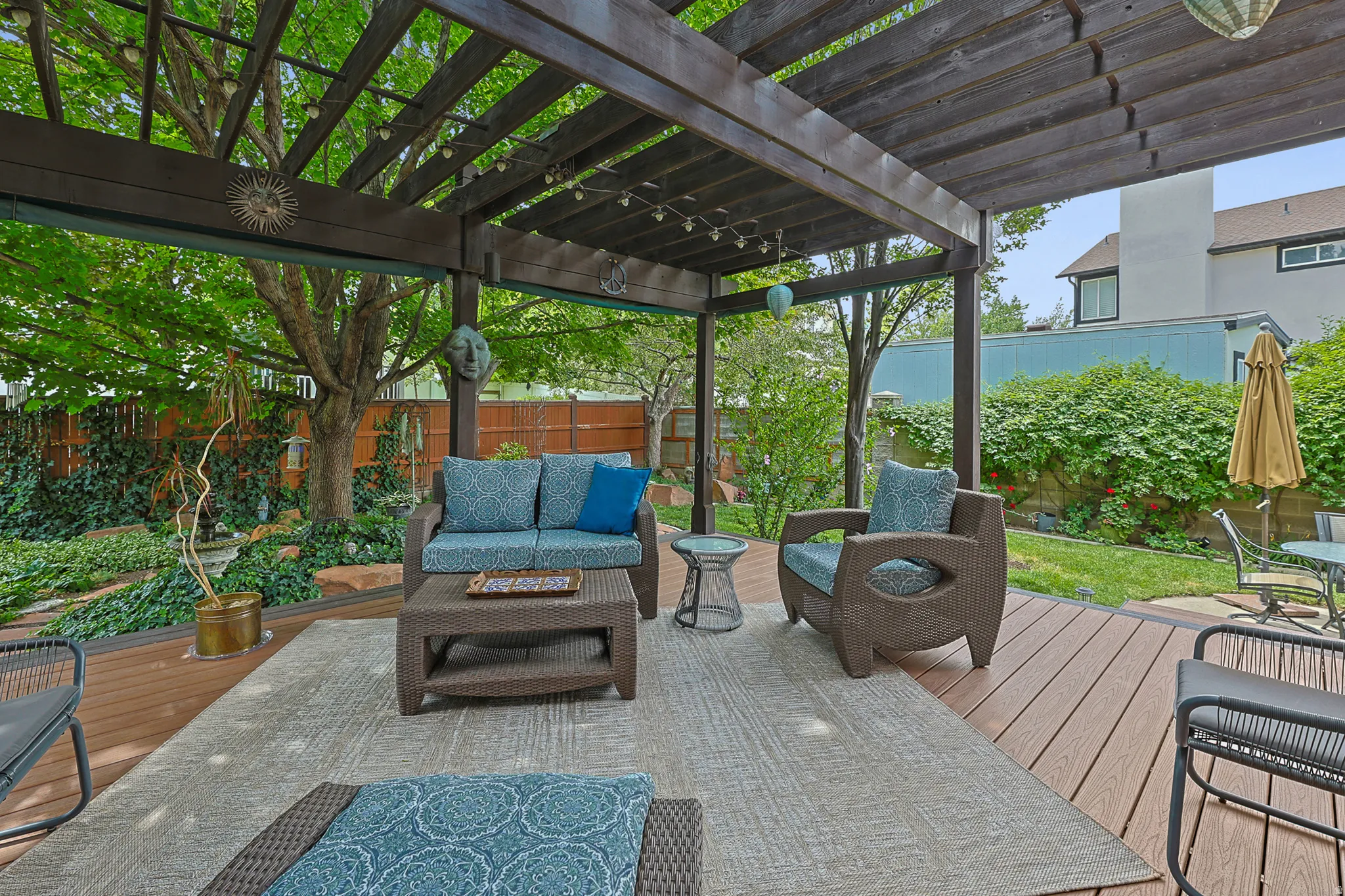 Expansive outdoor living area featuring a redwood  pergola, lighting, and trex style decking