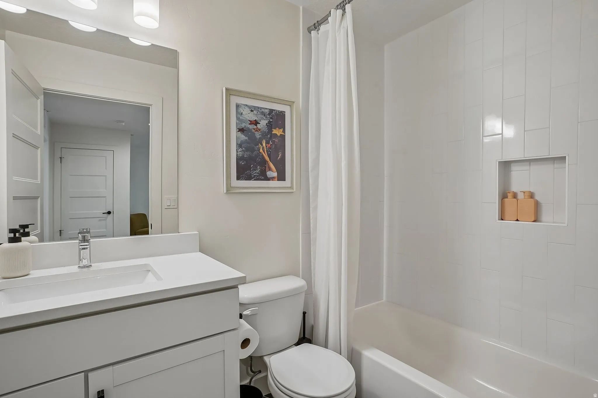 Contemporary bathroom featuring a vanity with an integrated sink, polished chrome faucet, and white countertop