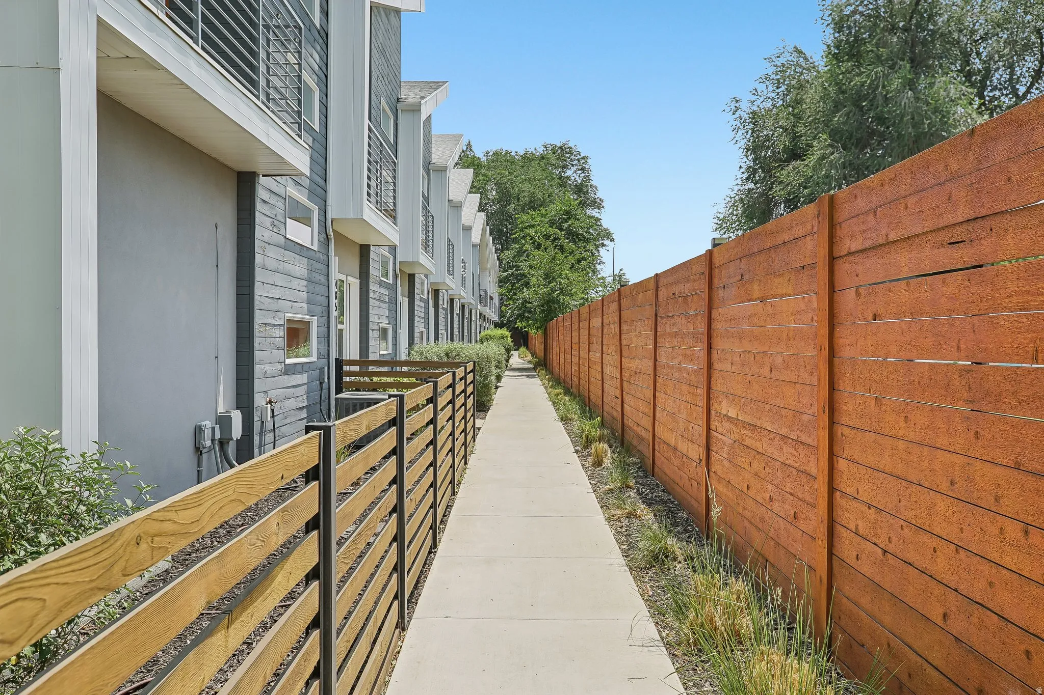 Modern row of townhomes featuring gray and white exteriors with horizontal siding