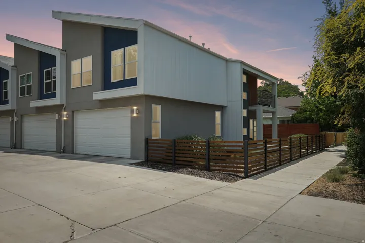 Contemporary exterior featuring a peaked roofline, gray stucco, and blue accents