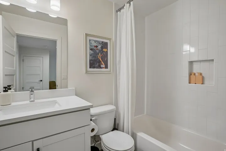 Contemporary bathroom featuring a vanity with an integrated sink, polished chrome faucet, and white countertop