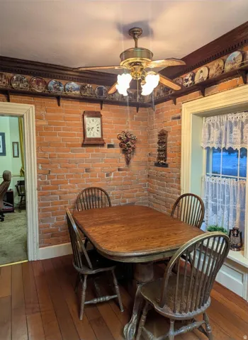 Exposed brick wall with decorative wood trim, complemented by wood-finish flooring