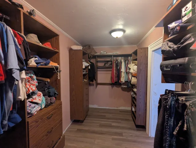 Master custom closet system featuring wood-finish cabinetry and shelving