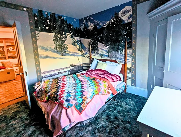 Bedroom with a feature wall showcasing a winter mountain mural