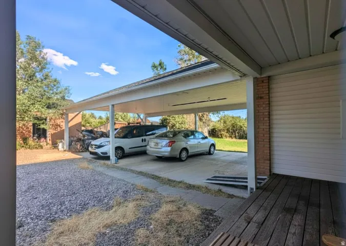 Expansive two-car carport with a concrete slab and direct access to a side entrance