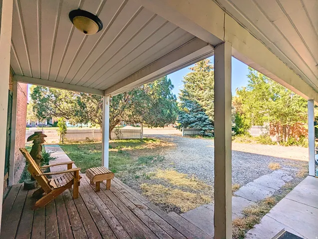 Covered porch with wood-finish flooring and a ceiling-mounted light fixture