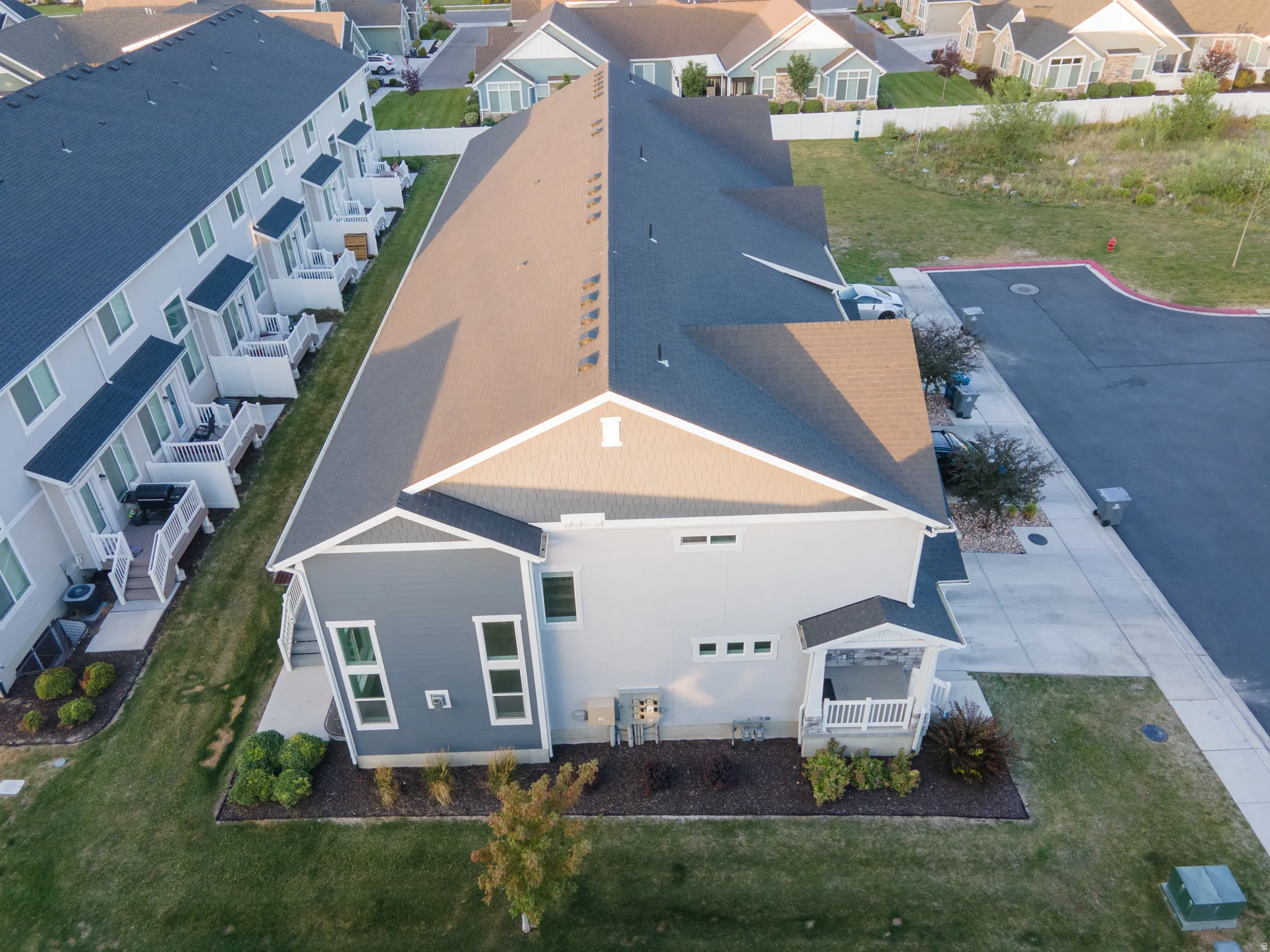 Multi-level townhome featuring a dark shingle roof, light-toned siding, and an inviting covered porch
