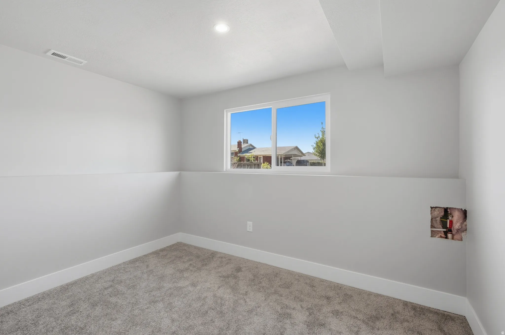 Recessed lighting, light gray carpet flooring, white trim, and a window