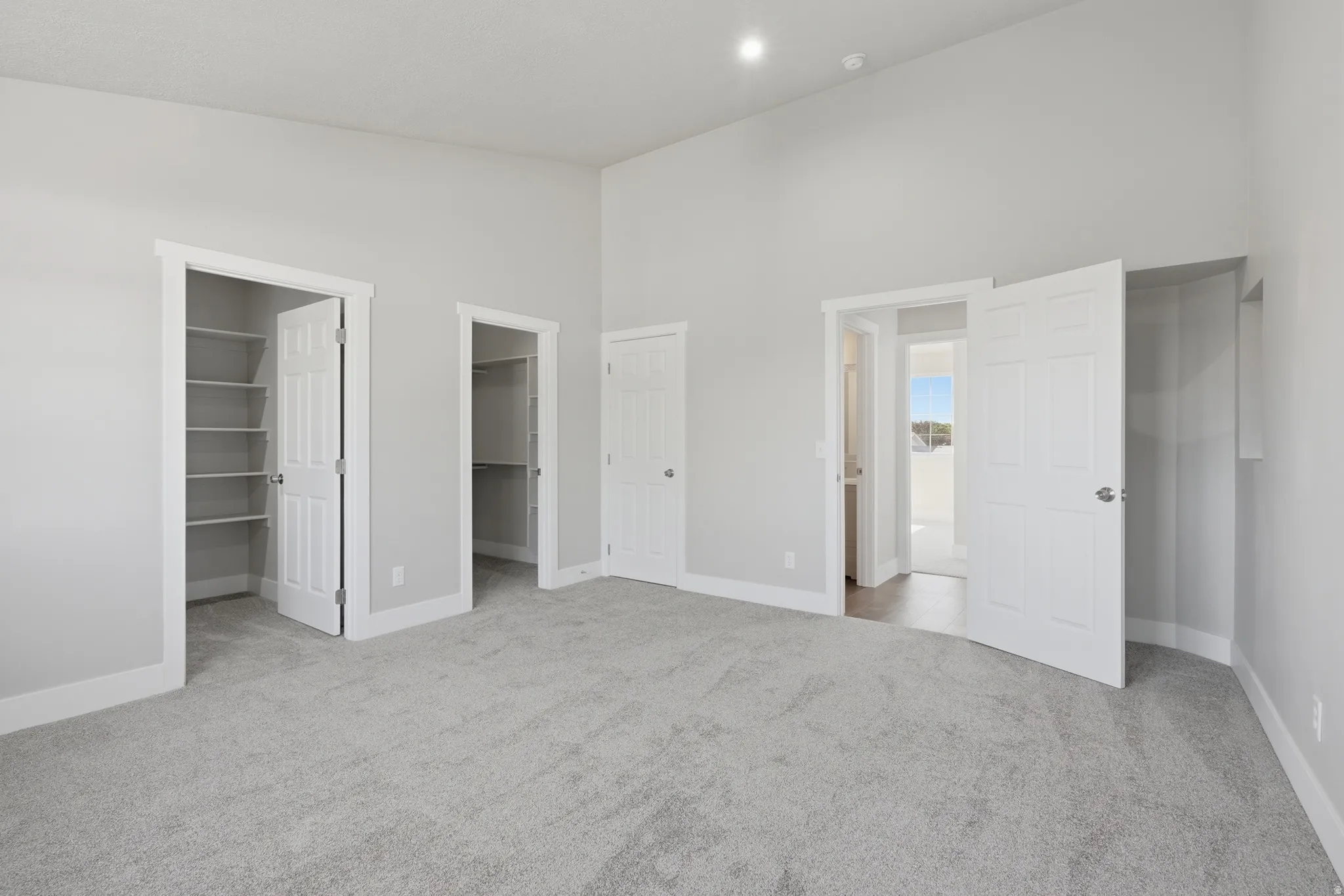 Spacious room featuring light gray carpeting and white trim
