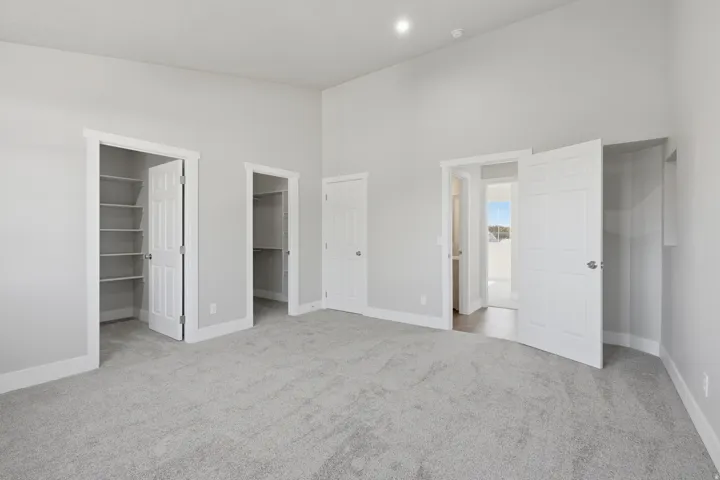 Spacious room featuring light gray carpeting and white trim