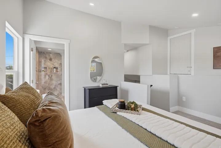 Bedroom featuring a vaulted ceiling, recessed lighting, and dual windows