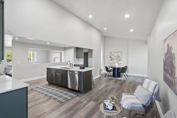 Kitchen island with dark cabinetry and a stainless steel dishwasher, contrasting with light countertops