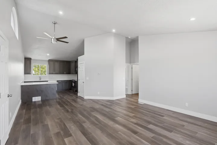 Open-concept living area featuring wood-finish flooring, vaulted ceilings, and recessed lighting