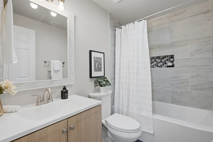 Full bathroom featuring a single vanity with wood-finish cabinetry and a white countertop