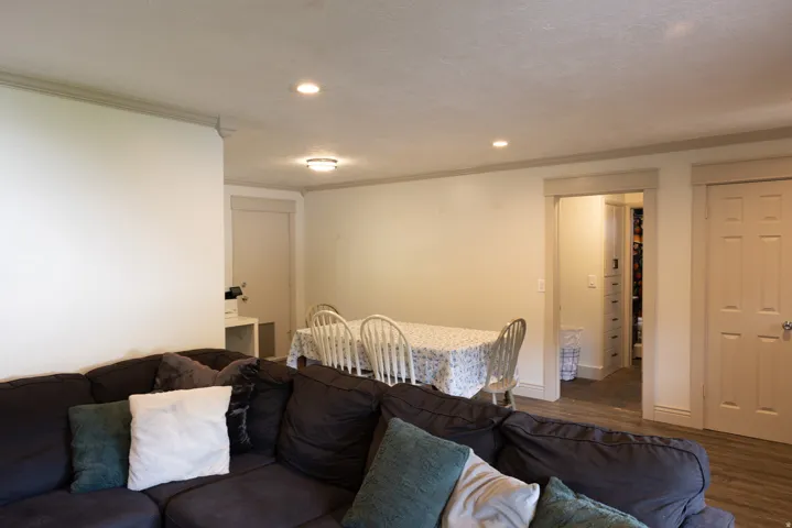 Open concept living area with recessed lighting, crown molding, a dining space, wood-finish flooring, and a paneled interior door