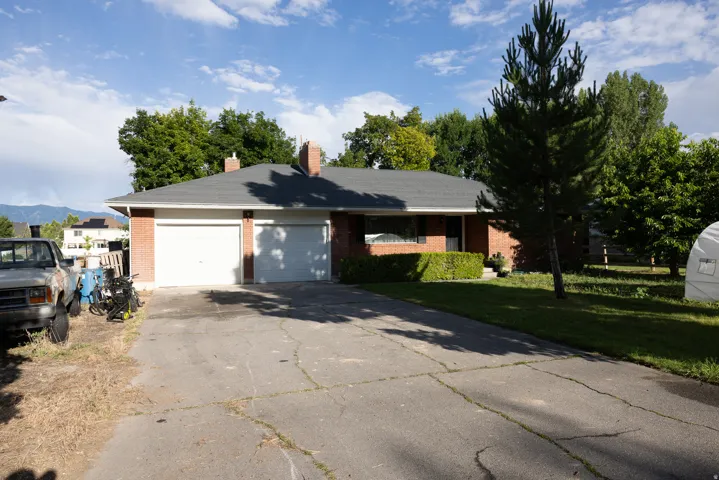 Brick exterior with a dark-shingled roof and two chimneys