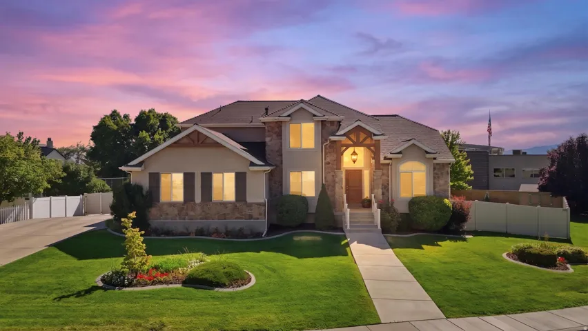 Stately two-story residence featuring a stone and stucco exterior, multiple gables, and decorative wood accents