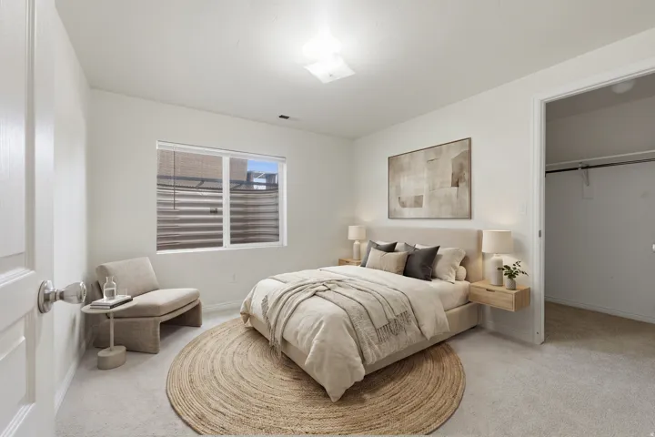 Bright bedroom with neutral wall tones and light-toned carpeting