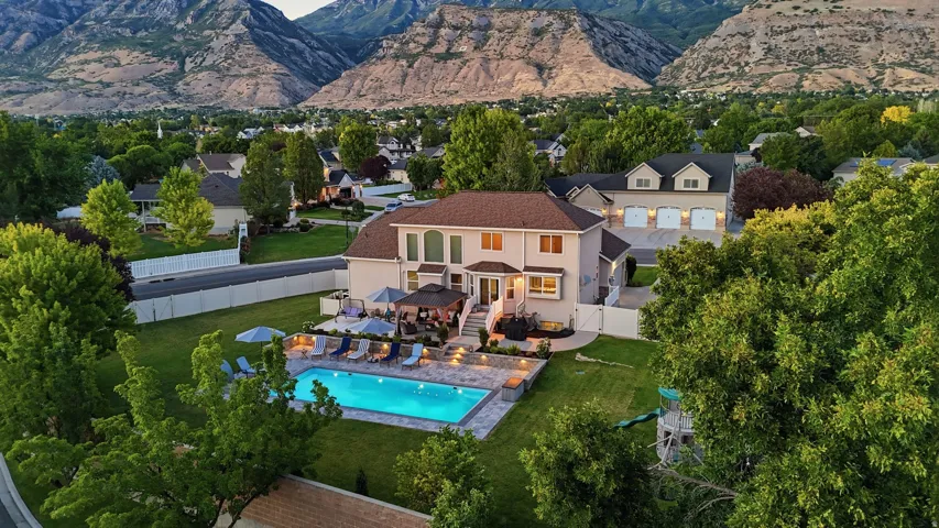 Expansive backyard featuring a large swimming pool and a surrounding patio