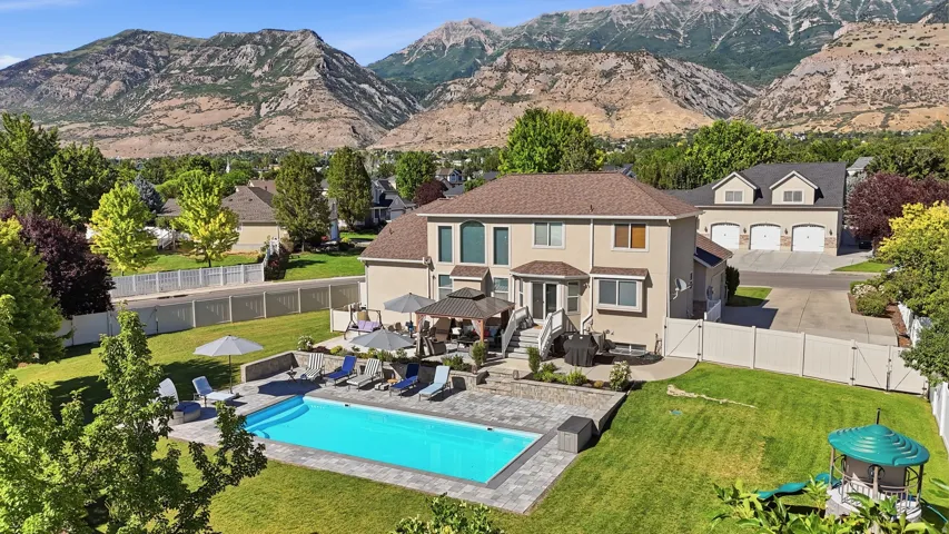 Spacious rear yard featuring an in-ground swimming pool, paver patio, and multi-level landscaping