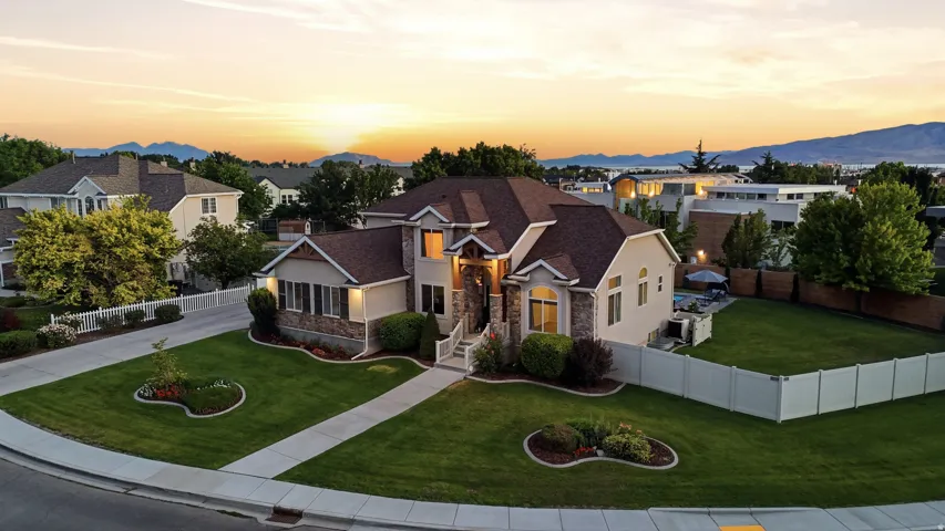 Multi-level residence featuring stone and stucco exterior, prominent entryway, and a brown shingle roof