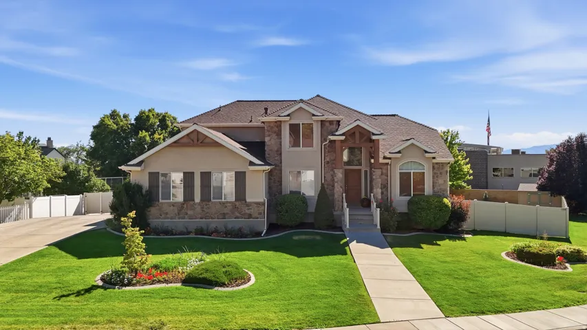 Stately stucco and stone-clad residence featuring a prominent entryway with wood beam accents