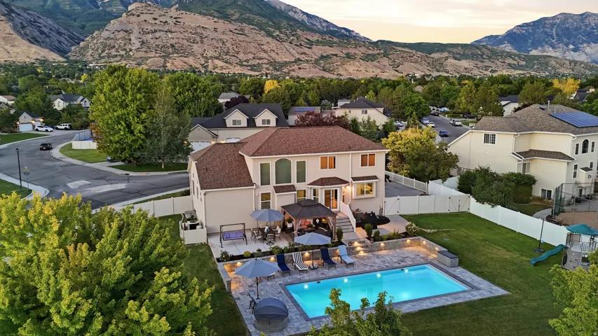 Expansive backyard featuring a rectangular swimming pool, integrated patio lighting, and a paved patio area