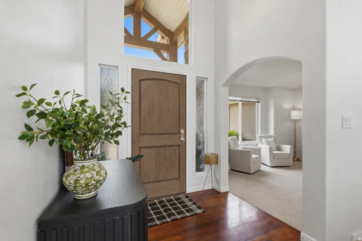 Entryway featuring a wood-finish door with decorative sidelights, transom window, and hardwood flooring