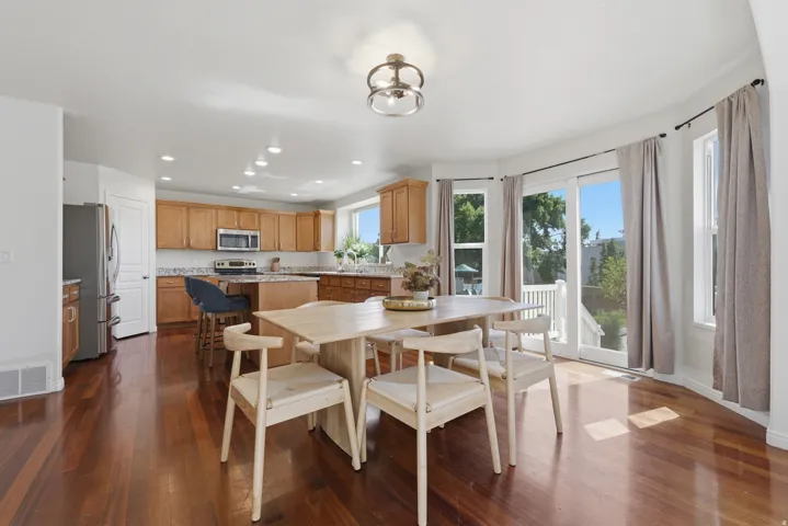 Open-concept kitchen and dining area featuring rich wood-finish flooring