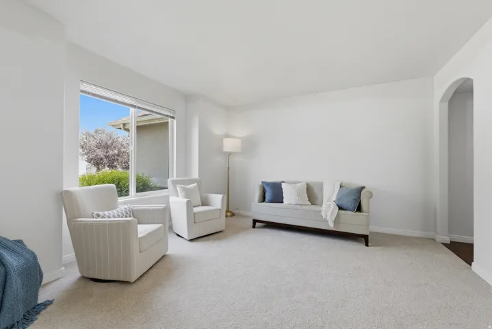 Spacious room featuring light-toned carpeting and a large picture window