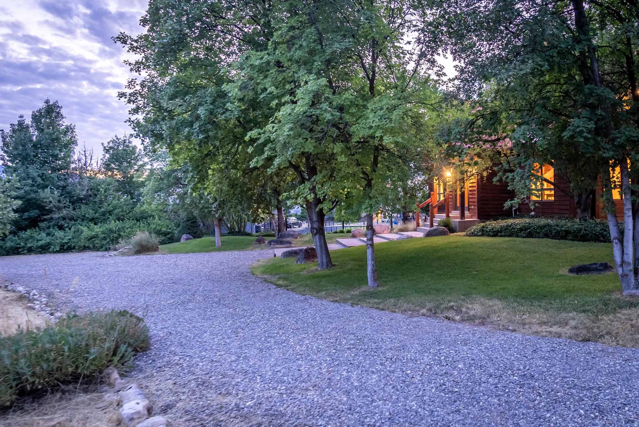 Gravel driveway leading to a log-sided home