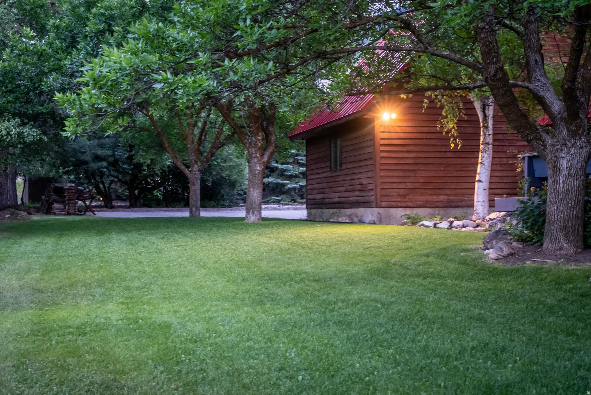 Expansive green lawn framed by mature trees