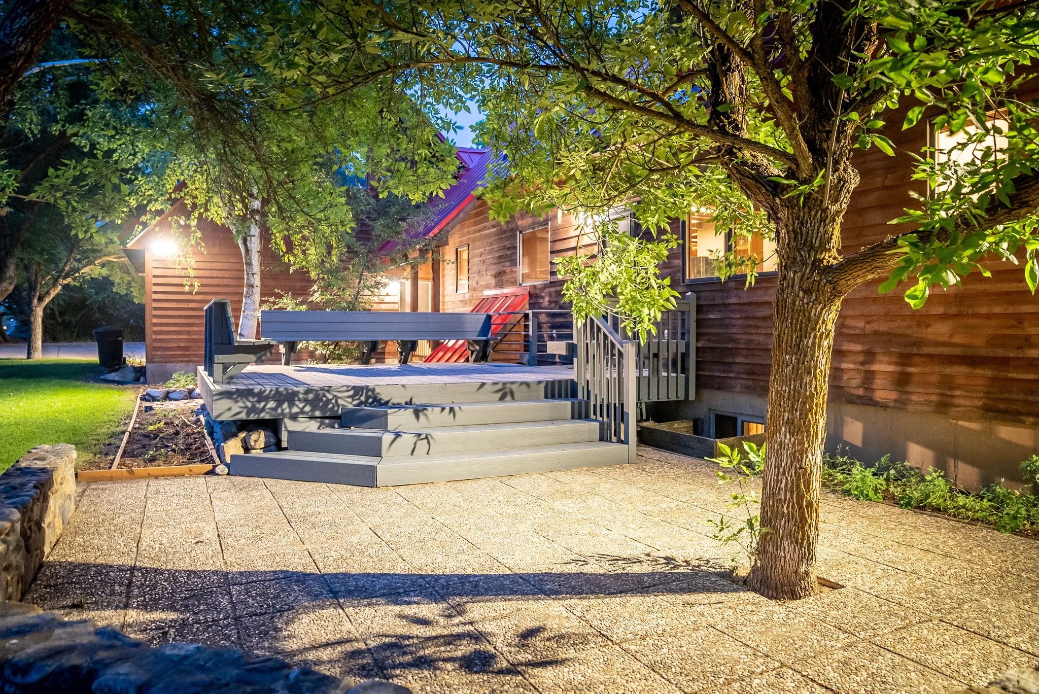 Expansive outdoor patio with concrete pavers and a built-in stone wall
