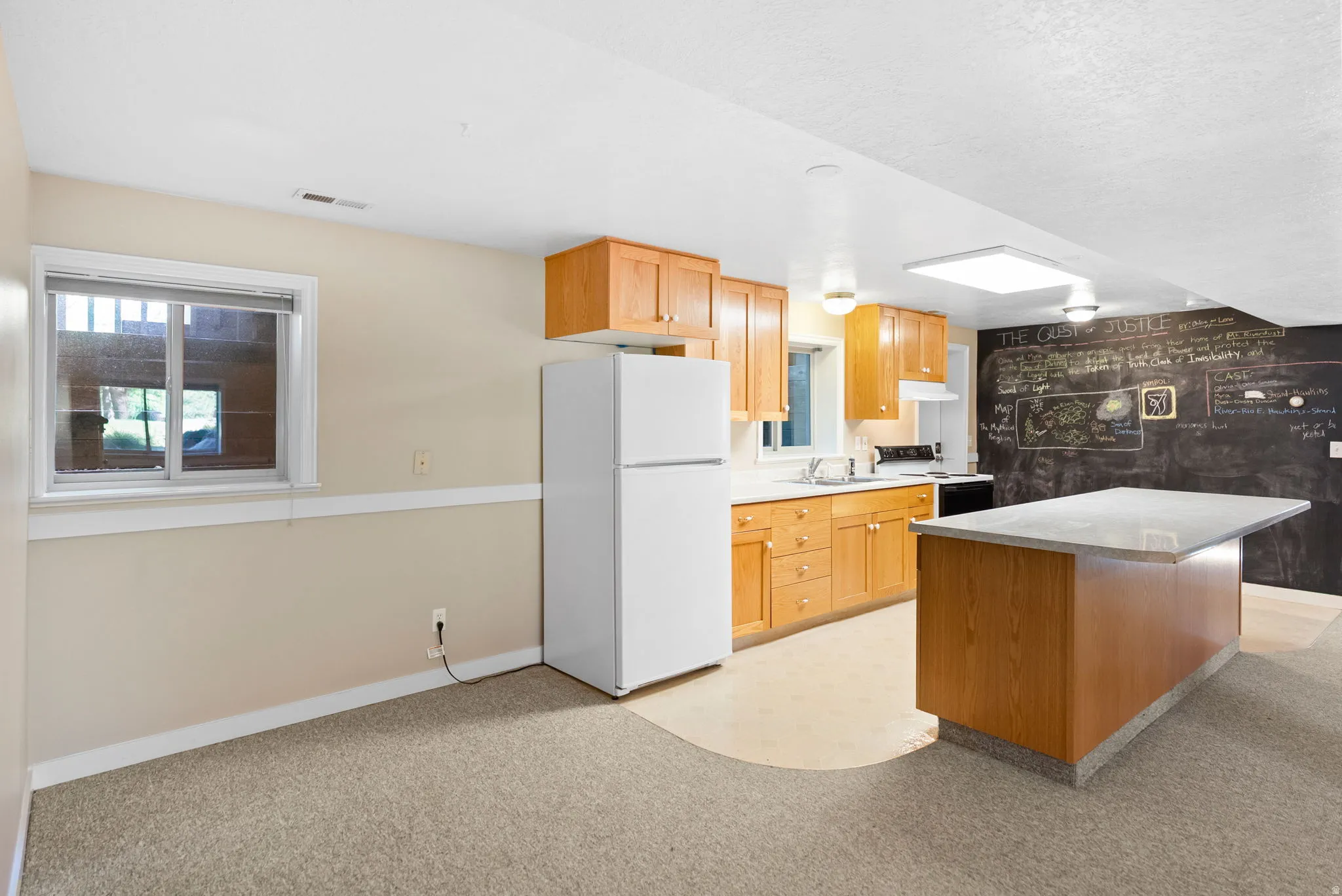 Well-appointed kitchen featuring wood cabinetry, white appliances, and a central island with a light-colored countertop