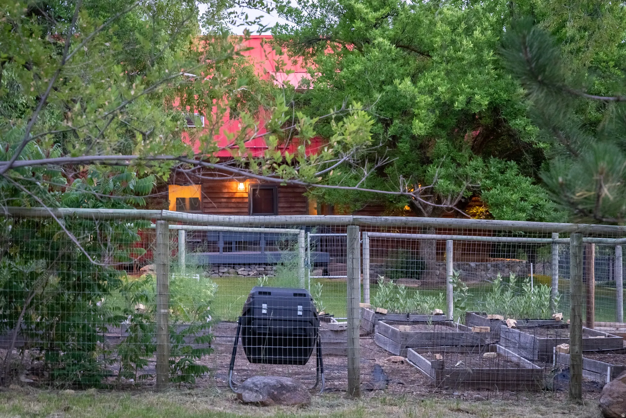 Rear property featuring a fenced garden area with multiple raised beds