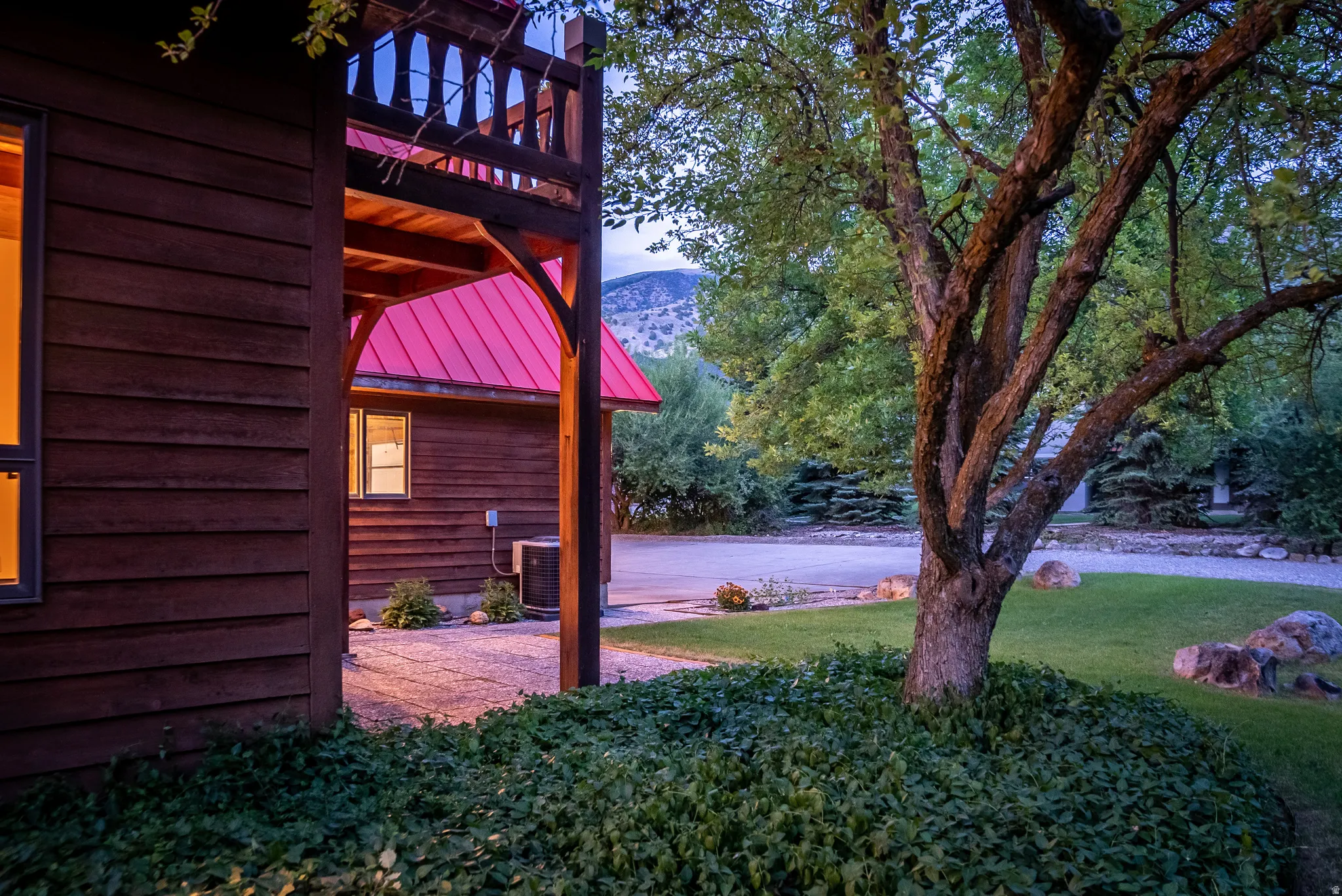 Wood-sided structure featuring a covered porch with a second-story balcony