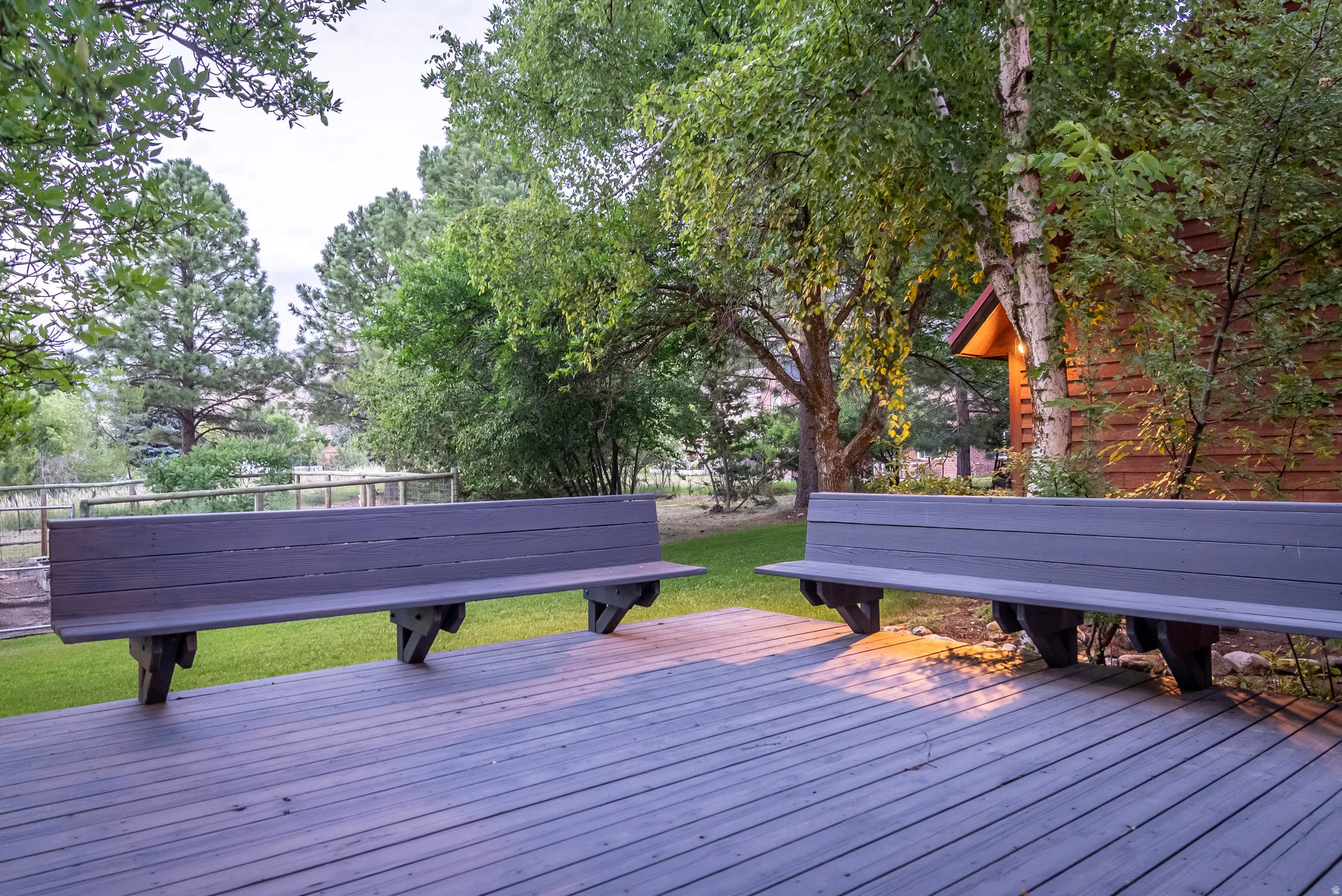 Expansive outdoor deck featuring wood-finish flooring and two built-in benches