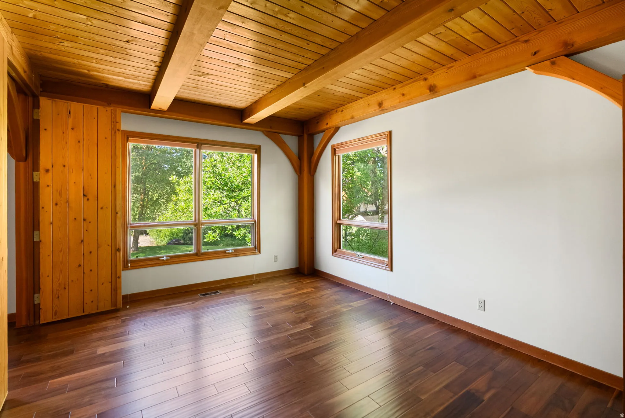 Room featuring exposed wood beams and planked ceiling