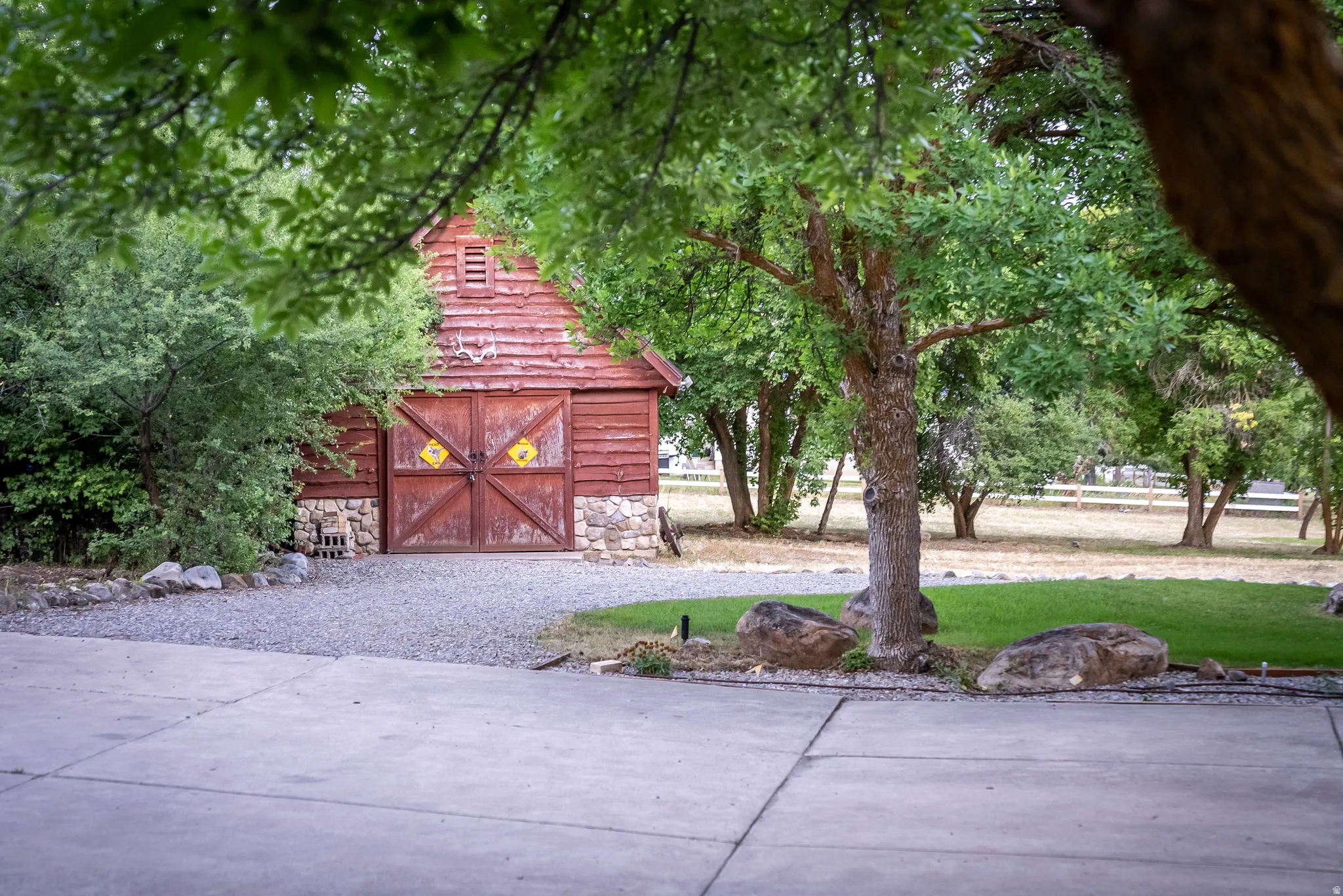 Redwood-sided barn with a stone foundation and dual wooden doors