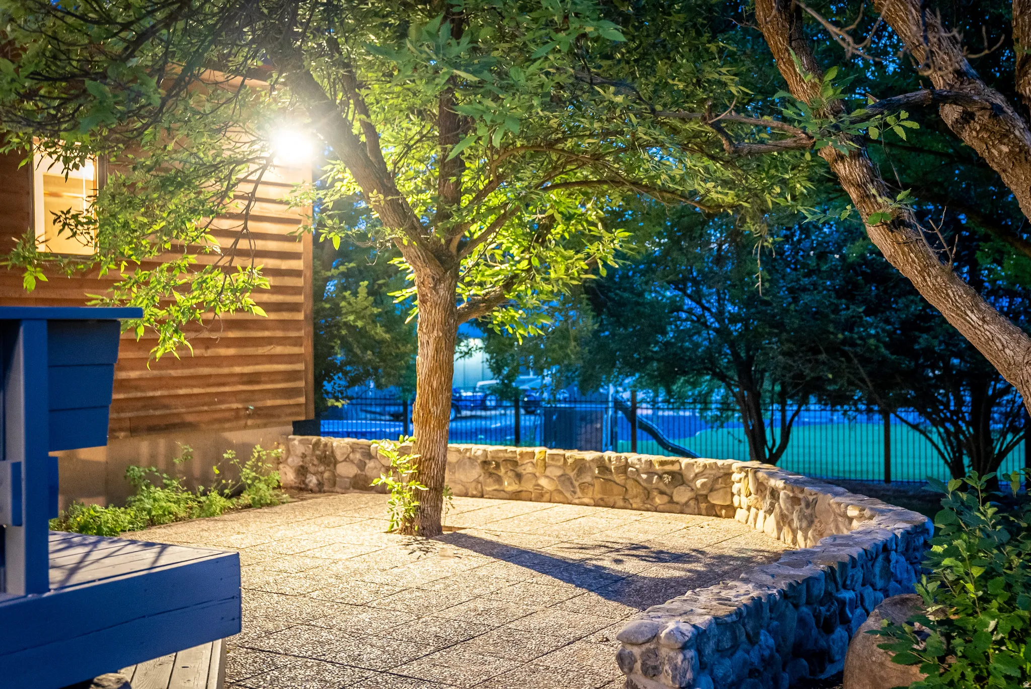 Patio area featuring exposed aggregate concrete surfacing and a curved stone retaining wall