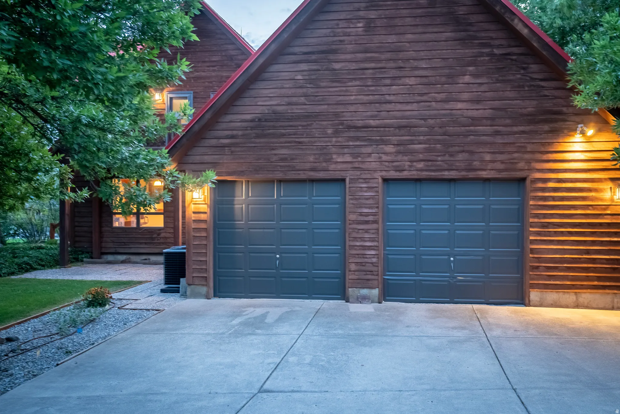 Two-car garage with dark paneled doors and a concrete driveway