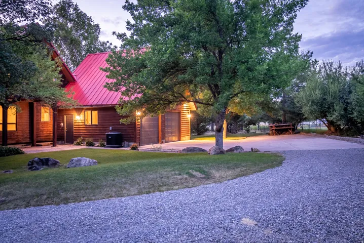 Rustic-style residence featuring a red metal roof and wood siding
