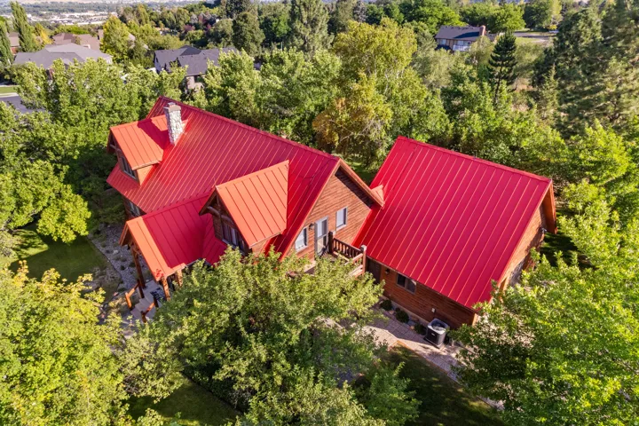 Wood-sided home featuring a prominent red metal roof
