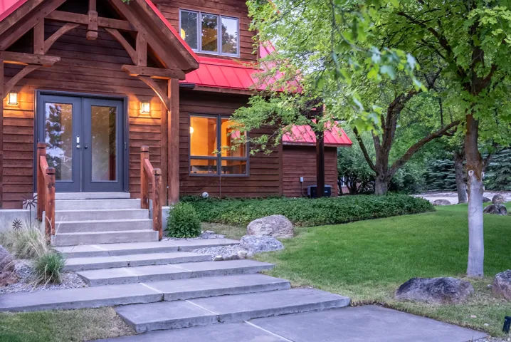 Wood-sided residence featuring a red metal roof and natural wood accents