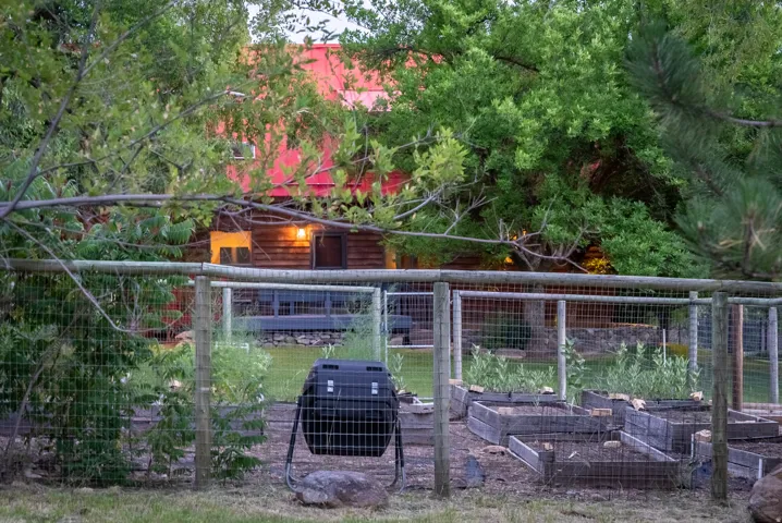 Rear property featuring a fenced garden area with multiple raised beds