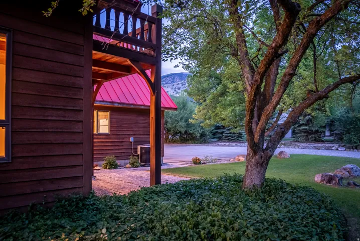 Wood-sided structure featuring a covered porch with a second-story balcony